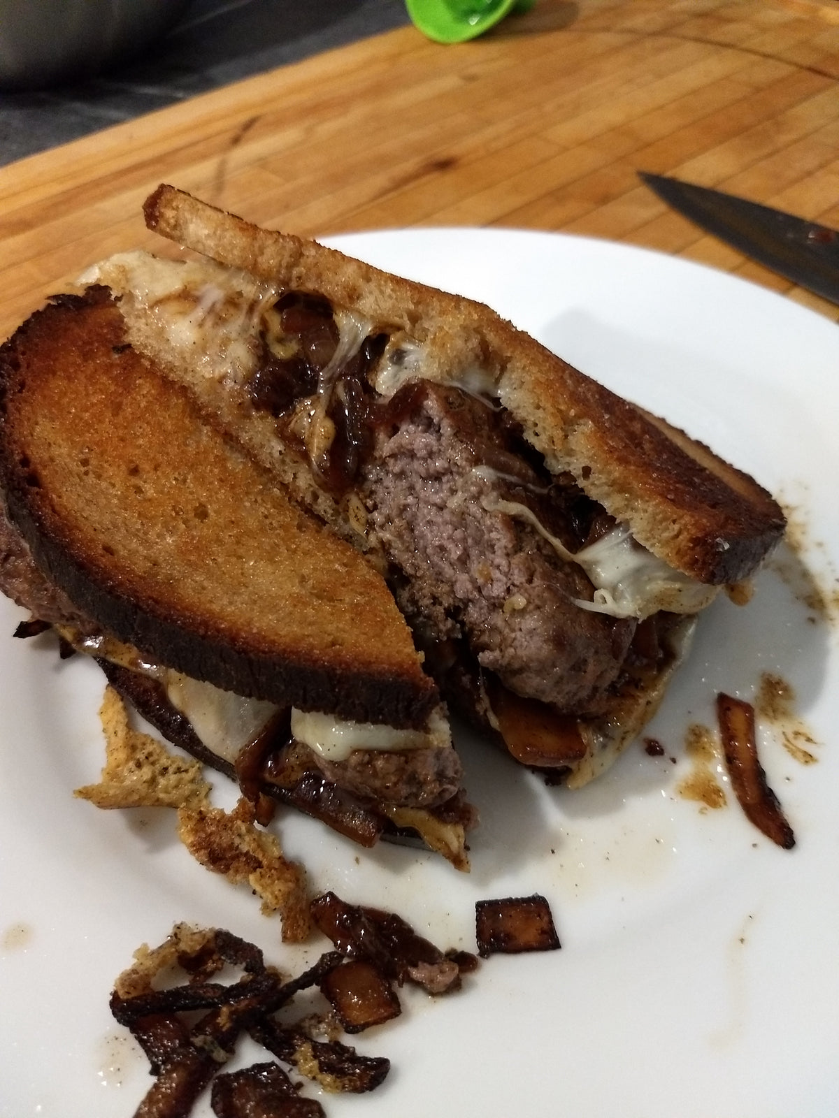 patty melt made on sourdough with fried onions and sauce on a plate