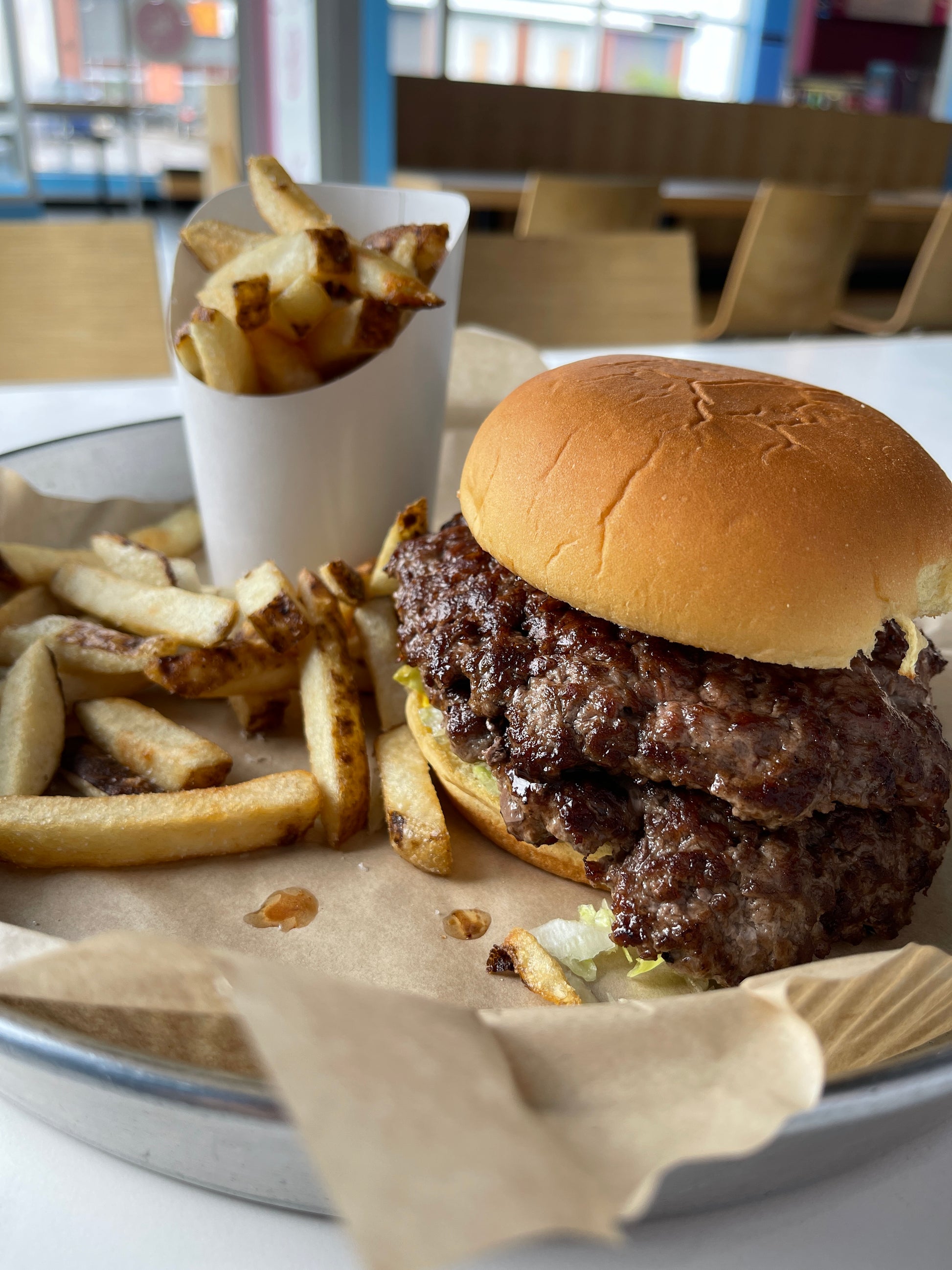 plain smash burger on a tray with a cone of fries
