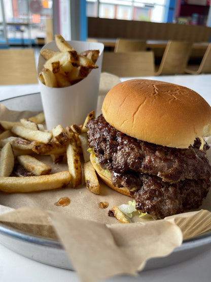 plain smash burger on a tray with a cone of fries