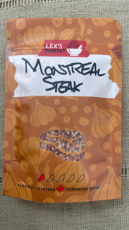A stand-up pouch of Lex's Pantry Montreal Steak seasoning mix, featuring an kraft-brown patterned background with garlic bulb and peppercorn illustrations, a white label, and a clear window showing the seasoning inside.
