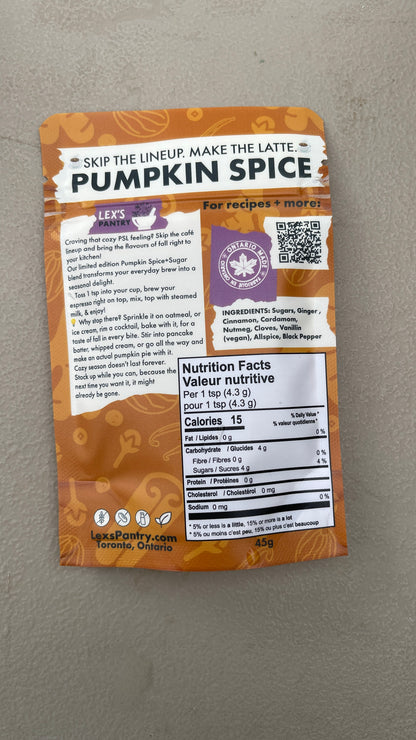 A single bag of Lex's Pantry Pumpkin Spice mix lies on a textured gray surface. The packaging is kraft-orange and white with black text, featuring the Lex's Pantry logo and an Ontario Made logo
