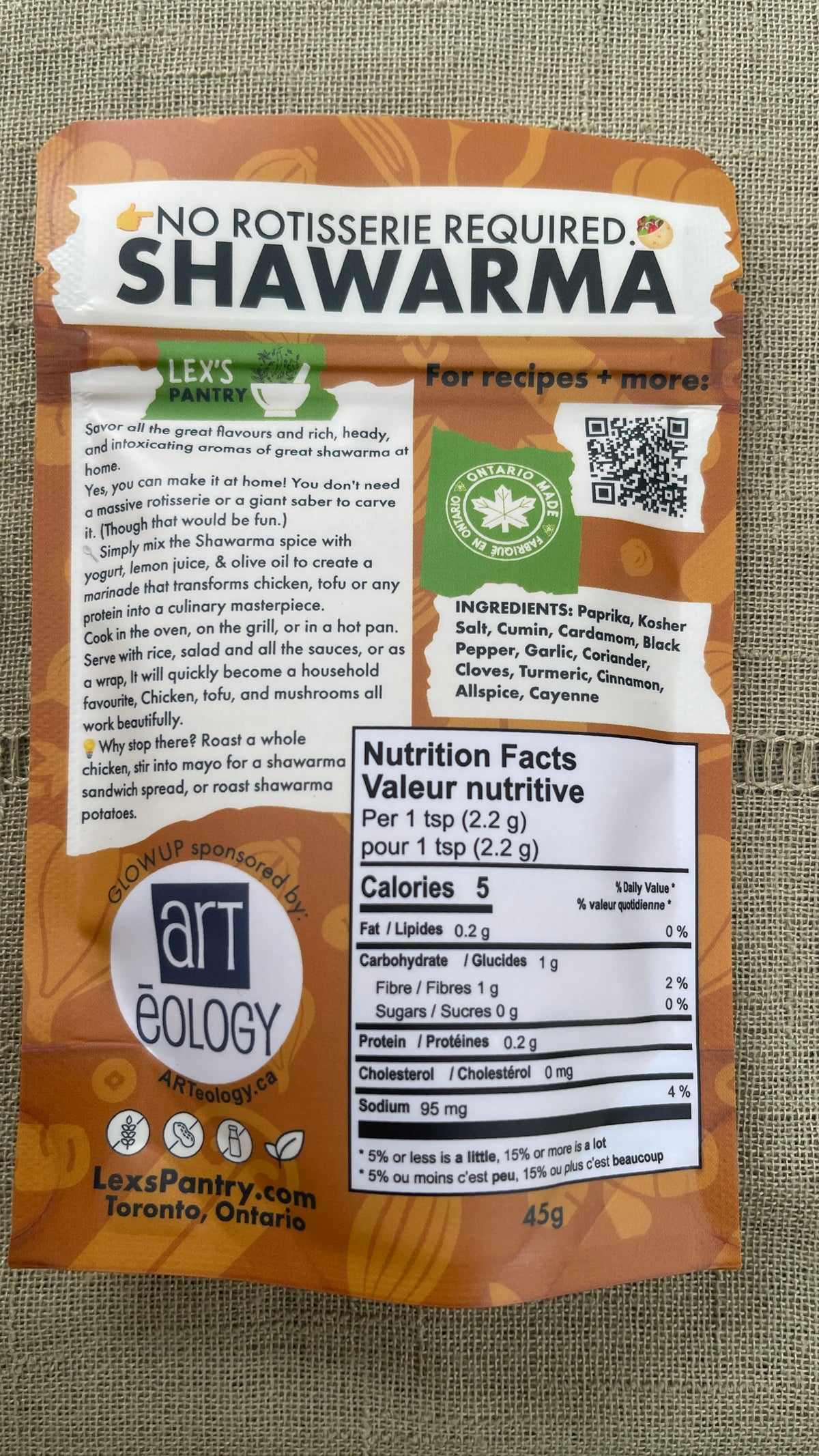 Back of a Shawarma spice & seasoning blend package from Lex's Pantry , featuring a kraft--brown design with a description, nutrition facts label, ingredient list, Ontario Made logo, and a QR code on a burlap background.