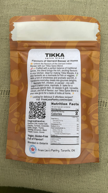 Back of a Tikka Masala Seasoning pouch from Lex's Pantry showing the printed ingredients, nutrition facts, QR code, and Ontario Made logo on a textured green fabric background.