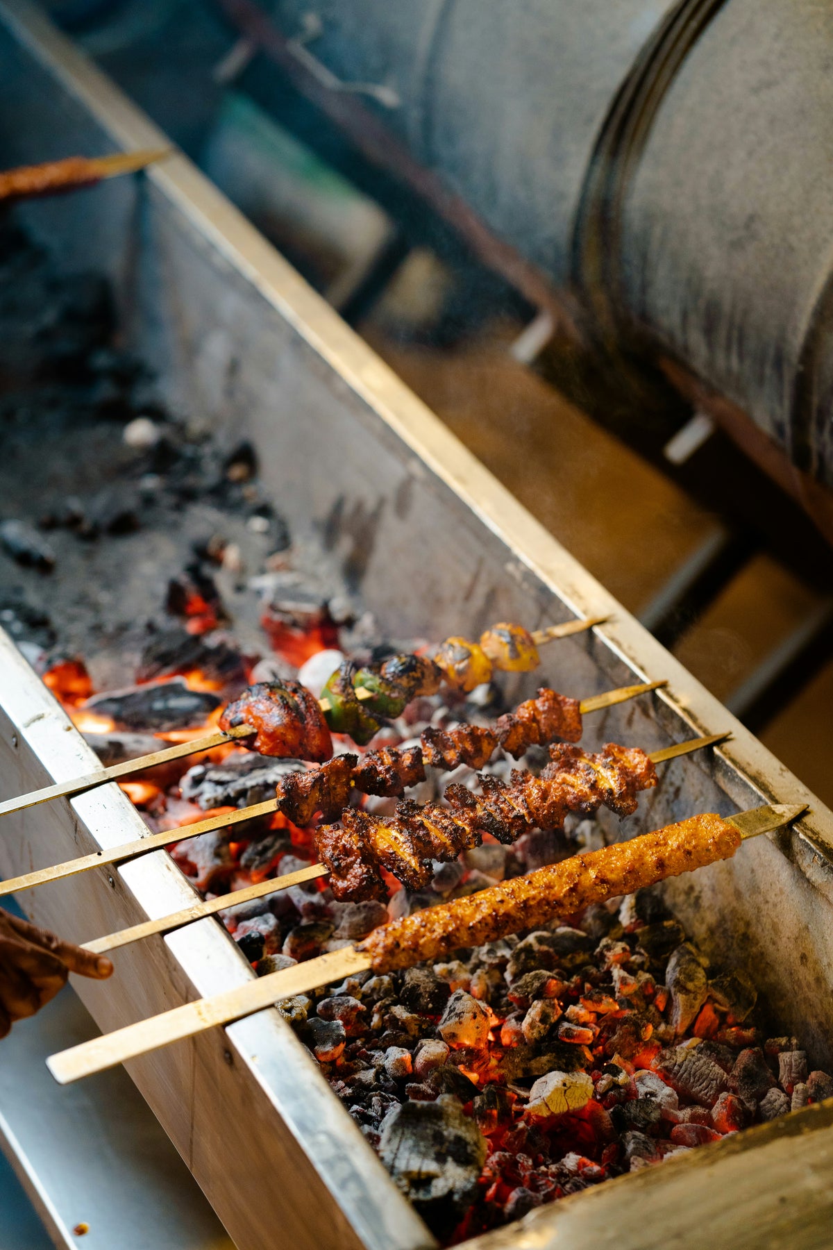 Skewers with food being grilled over a fire pit