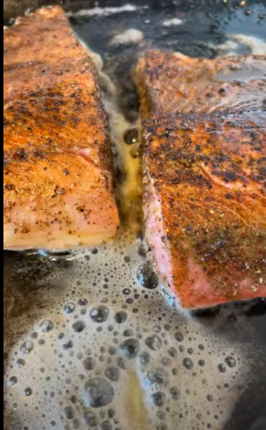 a sizzling pan of trout with Dirty Dill seasoning from Lex's Pantry.  on a cast iron pan with melted butter bubbling in the foreground